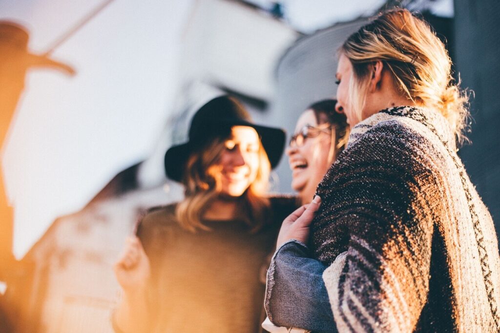 Group of women laughing together showing social connection and emotional support.